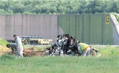 23日,救援专家检查坠毁飞机的残骸。