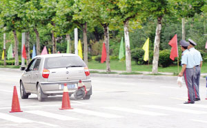 轿车飞驰而去，后面是被撞坏的隔离桩
