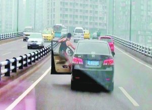一男子高速车道玩杂技 身体3次悬挂车外